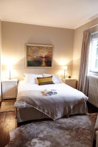 um quarto com uma cama grande e 2 candeeiros em Guest house La Maison Chantecler em Bruxelas