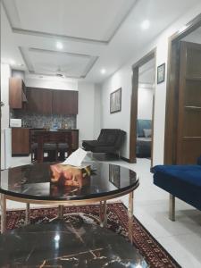 a living room with a table and a couch at Northern Suites Bahria town in Rawalpindi