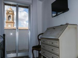 une commode dans une pièce avec une tour d'horloge dans l'établissement I colori della Sicilia NOBLESSE, à Caltagirone