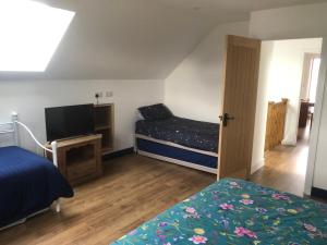 a bedroom with a bed and a flat screen tv at Lakeside Loft in Hereford