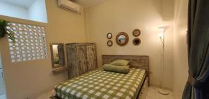 a small bedroom with a bed and a mirror at Ana homestay in Negara