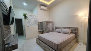 a bedroom with a bed and a tv in a room at Ana homestay in Negara