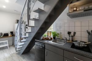 une cuisine avec un évier et un escalier dans l'établissement Arkadia Pension Norderstedt, à Norderstedt