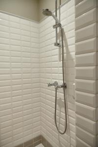 a shower stall in a bathroom with white tiles at Guest house La Maison Chantecler in Brussels