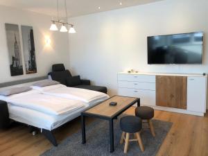 1 dormitorio con 1 cama y TV en la pared en WM-Appartements en Haus im Ennstal