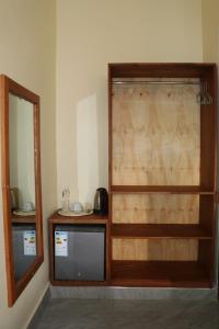 um quarto com uma televisão e um espelho num quarto em Verified Lodge em Dodoma