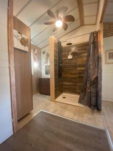 bagno con doccia e ventilatore a soffitto. di Chalet Valle di Corti a Pianottoli-Caldarello