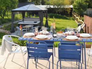 una mesa azul con sillas y copas de vino en el patio en Le Cémarose: spa, jardin, terrasse et jolie vue au cœur d'Epernay, en Épernay