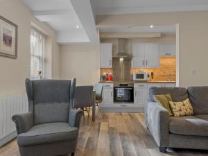 a living room with two chairs and a kitchen at Pass the Keys Newly Renovated 2 Bedroom Town Centre Apartment in Ulverston