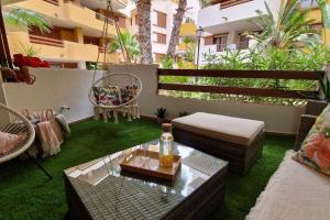 a patio with a couch and a table and chairs at Olivia Sunny 2 bedroom Apartament Punta Prima in Torrevieja
