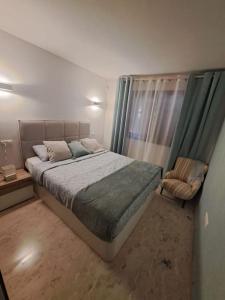 a bedroom with a large bed and a chair at Olivia Sunny 2 bedroom Apartament Punta Prima in Torrevieja +37 photos