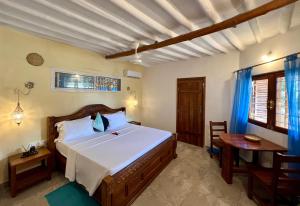a bedroom with a large bed and a table at Oleza Boutique Hotel Zanzibar in Michamvi