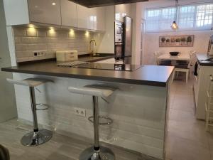 uma cozinha com um balcão com bancos em Luxurious Three Bedroom Duplex Apt Close to Beach em Fuengirola