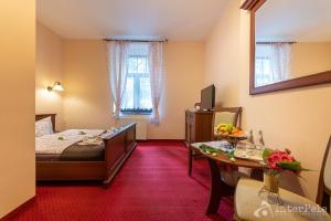 a hotel room with a bed and a table with a bowl of fruit at Willa Słoneczna Róża pokoje w centrum in Szklarska Poręba