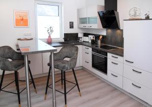a kitchen with a table and two bar stools at FeWo Varis in Röbel