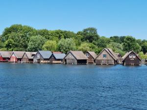 a row of wooden houses on a lake at FeWo Varis in Röbel