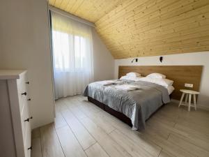 una camera con un grande letto e un soffitto in legno di Na Skraju Puszczy - nowo otwarty a Białowieża
