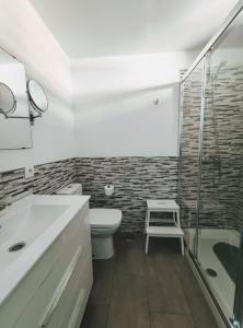 a bathroom with a toilet and a glass shower at Casa Royal Los Cristianos Center in Los Cristianos +17 photos