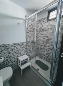 a bathroom with a shower with a toilet and a stool at Casa Royal Los Cristianos Center in Los Cristianos