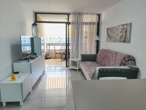a living room with a couch and a tv at Casa Royal Los Cristianos Center in Los Cristianos