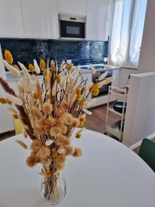 維洛納的住宿－MARCO POLO APARTMENT，花瓶里满是干花,坐在桌子上