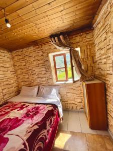 um quarto com uma cama numa parede de tijolos em GuestHouse Lokthi em Theth