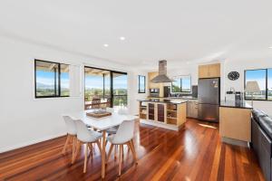 a kitchen and dining room with a table and chairs at Jetty Escape Townhouse 1 Mildura Street 66 Coffs Harbour in Coffs Harbour