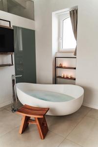 a white bath tub in a bathroom with a window at Le Vie Del Centro Luxury Room in Matera