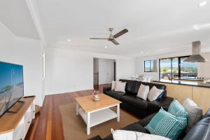 uma sala de estar com um sofá preto e uma mesa em Jetty Escape Townhouse 1 Mildura Street 66 Coffs Harbour em Coffs Harbour