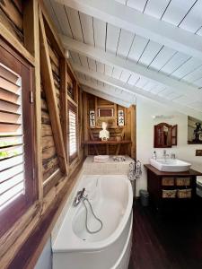 baño grande con bañera y lavamanos en La Voile Grise - Villa de charme - Sea View en Le Gosier