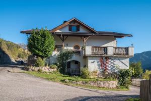 une maison avec un balcon sur le côté d'une route dans l'établissement Gfinkerhof Mendel, à Vols am Schlern