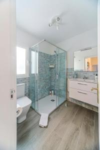 a bathroom with a glass shower and a toilet at Luxury Beach Sea Front Guanarame in Playa Honda