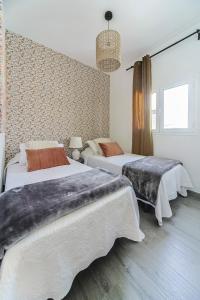 1 dormitorio con 3 camas y ventana en Luxury Beach Sea Front Guanarame, en Playa Honda