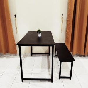 ein schwarzer Tisch und ein Stuhl mit einer Topfpflanze darauf in der Unterkunft Rezqrich Villa Homestay 1 in Kampung Degong