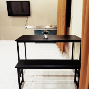ein schwarzer Tisch mit einer Pflanze darüber in der Unterkunft Rezqrich Villa Homestay 1 in Kampung Degong