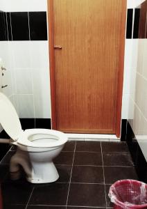 ein Badezimmer mit einem WC und einer Holztür in der Unterkunft Rezqrich Villa Homestay 1 in Kampung Degong