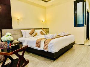 a bedroom with a large bed and a table at Tara Palace Resort and SPA in Gangtok