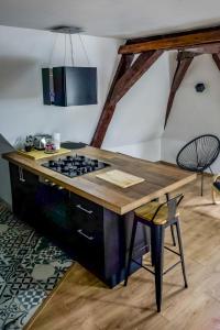 une cuisine avec un comptoir, une cuisinière et un tabouret dans l'établissement Vue sur la cathédrale - Au cœur de Bourges, à Bourges
