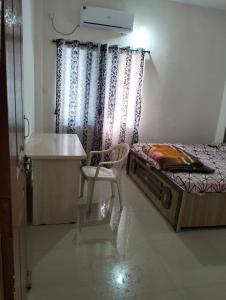a bedroom with a bed and a desk and a chair at Agarwal Guest House in Naya Raipur
