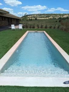 a swimming pool with two chairs in a yard at Alojamiento rural de lujo en Pedraza-Tejadilla in Valleruela de Pedraza