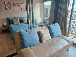 a living room with a leather couch with blue pillows at La Casita Huahin by Ying in Hua Hin