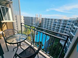 balcone con tavolo, sedie e vista su un edificio di La Casita Huahin by Ying a Hua Hin