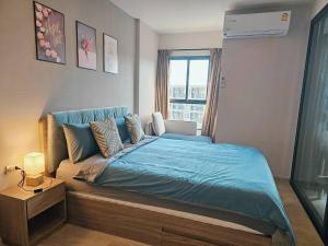 sypialnia z łóżkiem z niebieską pościelą i oknem w obiekcie La Casita Huahin by Ying w mieście Hua Hin