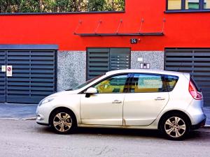 un coche blanco estacionado frente a un edificio rojo en L' appartamento sul Naviglio en Milán