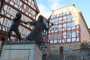 Une statue de deux femmes devant un bâtiment dans l'établissement Ferienwohnung Stellberg, à Homberg