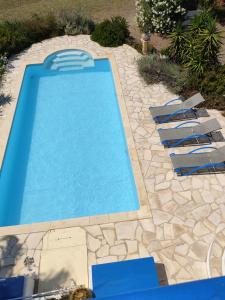 a swimming pool with lounge chairs in a yard at Villa Caretta - direkt an einem einsamen Strand im Süden des Peloponnes 