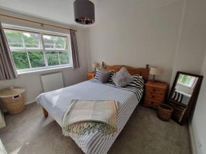 een slaapkamer met een bed en 2 ramen bij Modern 2 bedroom home with ample parking in Henwick