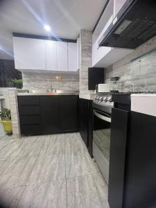 uma grande cozinha com armários pretos e um fogão em Galeras 103 em Bogotá