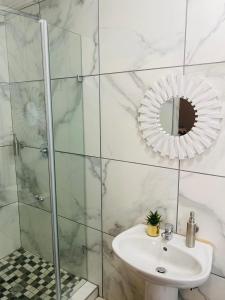 a white bathroom with a sink and a mirror at Suite Boutique Lodge in Pretoria