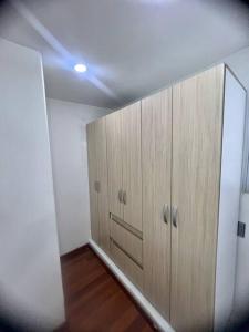 um corredor com armários de madeira num quarto em Galeras 103 em Bogotá